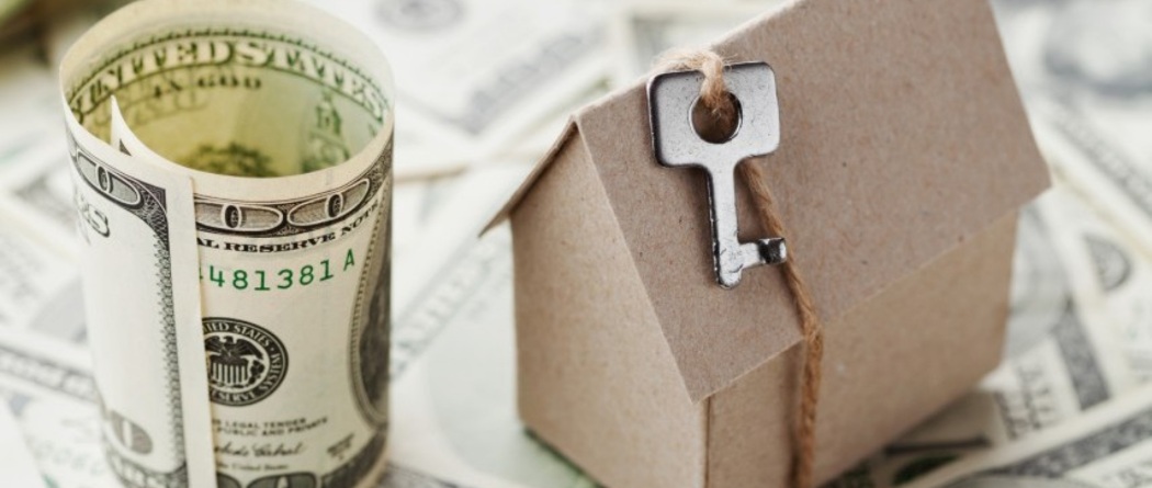 a money and a brown paper house
