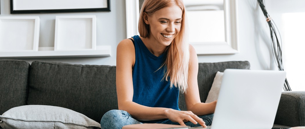 a woman on her couch viewing her laptop